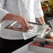 A person using an Avantco countertop food warmer to prepare food in a large pan.