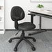 A Boss black office chair with wheels and adjustable arms.