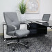 A Boss gray leather office chair at a desk with a laptop.