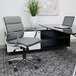 A gray Boss CaressoftPlus office chair at a desk with a laptop and a white vase with a plant on the side