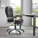 A Boss black office chair with wheels and a chrome base.