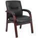 A Boss black leather guest chair with mahogany wood legs.