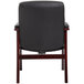 A Boss black leather guest chair with mahogany wood legs.