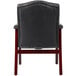 The back of a Boss black leather Ivy League guest chair with mahogany finish.