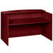 A mahogany laminate reception desk with a shelf on top.