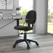 A Boss black tweed office chair with wheels at a desk.