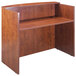 A Boss cherry laminate reception desk shell with a shelf.