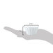 A hand holding a small white flared ramekin with a shadow