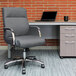 A Boss slate gray linen office chair at a desk with a black laptop.