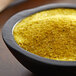 A bowl of yellow powder with "Regal Southwestern Blend" on a table.