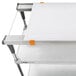A white cutting board on a metal shelf.