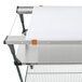 A white cutting board with orange handles on a metal shelf.