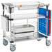 A Metro PrepMate MultiStation with stainless steel shelving and trays on wheels.