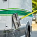 A person cleaning a white vehicle with a Carlisle Sparta Flo Thru vehicle cleaning brush.