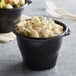 A bowl of macaroni and cheese in a black plastic Fabri-Kal SideKicks container.
