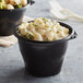A bowl of macaroni and cheese in a black Fabri-Kal microwaveable container.