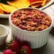 A white fluted Hall China ramekin filled with fruit.