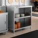 A stainless steel dish cabinet with an adjustable midshelf, holding stacks of plates.