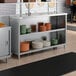 A stainless steel dish cabinet with an adjustable midshelf, holding stacks of plates and bowls.