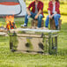 A man and woman sitting on a campground with a CaterGator camouflage cooler on a table.