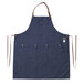 A navy blue canvas apron with brown straps.
