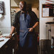 A man wearing a Hardmill navy canvas apron.