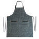 A grey Hardmill apron with black straps hanging on a counter.