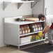 A man putting food on a Regency stainless steel shelf in a professional kitchen.