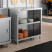 A stainless steel dish cabinet with an adjustable midshelf, shown holding stacks of plates.