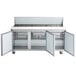 An Avantco stainless steel refrigerated sandwich prep table with two open doors.