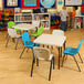 A pack of white Lifetime children's stacking chairs with green seats.