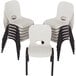 A stack of white Lifetime children's stacking chairs with a hole in the back.
