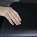 A hand on a black ES Robbins chair mat.