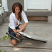A woman sitting on the ground using a Lifetime almond personal folding table.