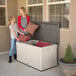 A woman and girl standing next to a Lifetime outdoor storage deck box filled with pillows.