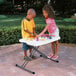 A boy and girl playing on a Lifetime white personal folding table.