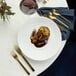 A close-up of a Oneida Chef's Table Gold stainless steel dinner fork on a plate of food
