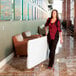 A woman walking next to a Lifetime white granite folding table.