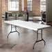 A white Lifetime plastic folding table on a tile floor.