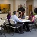 A group of people sitting at a Lifetime white granite folding table.