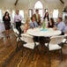 A group of people sitting around a Lifetime almond plastic folding table.