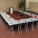 a long table with chairs and a vase of red liquid