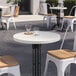 A white Art Marble Furniture round table on a brick patio.