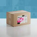 A brown box with a label that reads "Adourne Fine Pink Sanding Sugar" and pink and white squares.