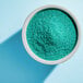 A bowl of Adourne Light Green Sanding Sugar.