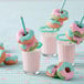 A group of donuts with milk and straws on a white background.