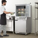 A man in an apron standing in front of a Beverage-Air undercounter refrigerator.