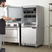 A man standing in front of a large silver Beverage-Air undercounter freezer on wheels.