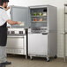 A man opening the left door of a white Beverage-Air undercounter refrigerator.