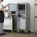 A man in a black apron opening a Beverage-Air undercounter freezer.